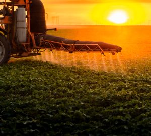 Tractor spraying pesticides on soybean field  with sprayer at spring